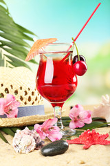 Refreshing cherry cocktail on sand beach