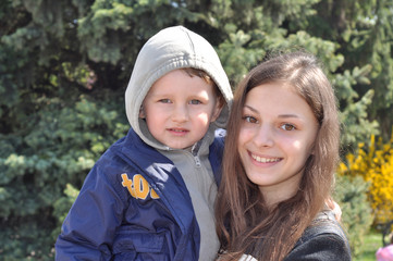 Funny baby and girl on a walk in the park
