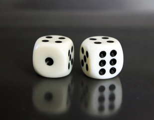 two white dices over black background
