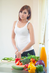 Obraz na płótnie Canvas Happy woman cooking vegetables green salad