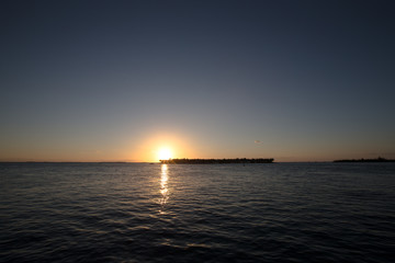 Fototapeta premium sunset over an island in the ocean