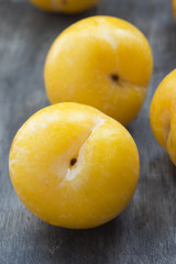 Yellow plums on dark wooden table