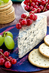 Blue cheese with fruits on wooden background