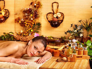 Woman getting massage in bamboo spa.