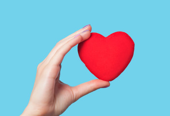 Hands holding shape heart on blue background