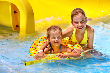 Children sitting on inflatable ring.