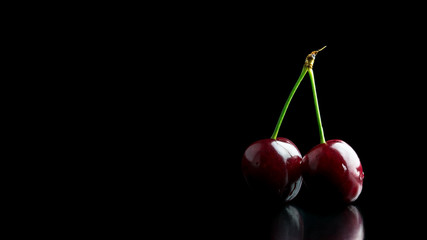 Two ripe red cherries