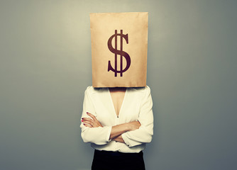 woman hiding under paper bag with dollar sign