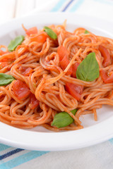 Pasta with tomato sauce on plate on table close-up