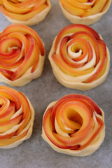 Obraz na płótnie Canvas Tasty puff pastry with apple shaped roses on pan close-up