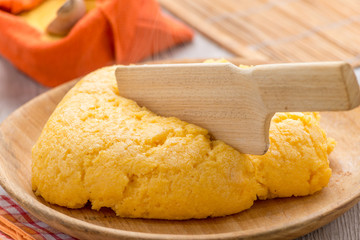 polenta gialla su piatto di legno