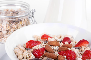 Healthy cereal in bowl with milk and strawberries closeup