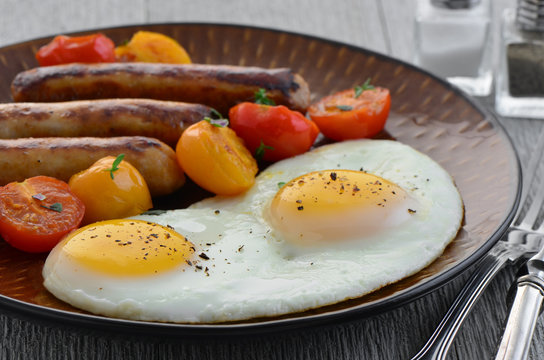 Fried eggs, sausage and cherry tomatoes