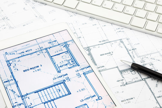 house blueprints and floor plan with tablet