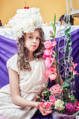 Pretty little girl posing with flower arrangements