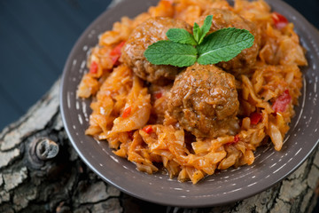 Braised cabbage and meatballs decorated with mint leaves