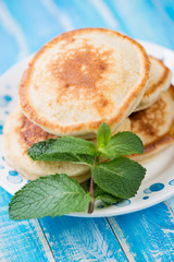 Fritters with mint leaves, blue wooden background, studio shot