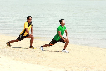 two man exercise on the beach