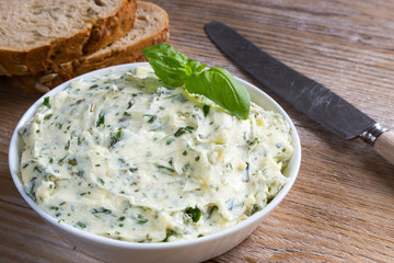 Kräuterbutter in einer Schale auf Holz
