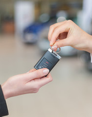 Woman hand holding a car key and handing it over