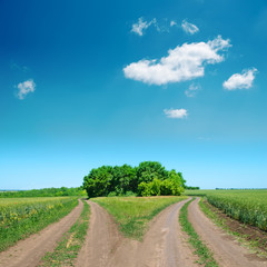 Fototapeta na wymiar crossing of two rural road and deep blue sky