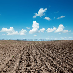 Fototapeta na wymiar black plowed field after harvesting under blue sky