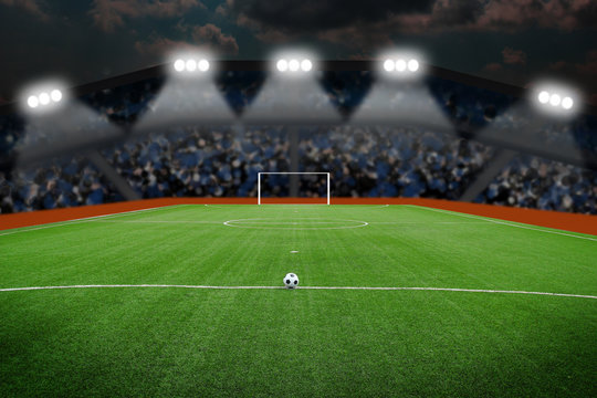 Soccer ball on field in stadium at night
