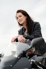 Fototapeta na wymiar cheerful and beautiful young woman riding motorbike