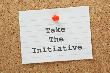 The phrase Take The Initiative on a cork notice board