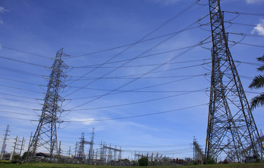 Electricity poles and wires against dramatic blue cloudy sky