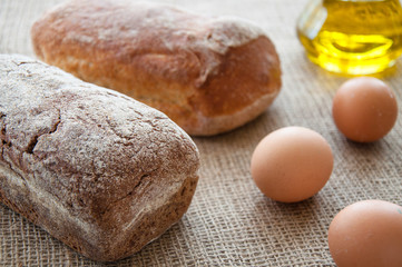 Homemade bread ciabatta on the table. Olive oil, eggs and flour