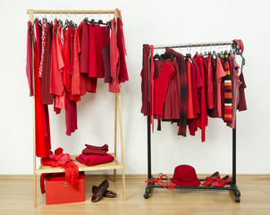 Wardrobe with red clothes hanging on a rack nicely arranged.