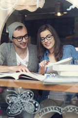 Hipster couple studying together at cafe