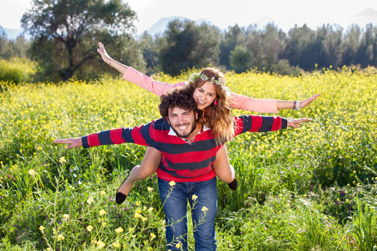 Young couple frolicking in the countryside.