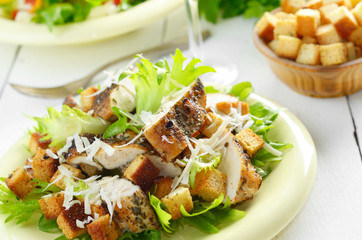 Caesar chicken salad on white table