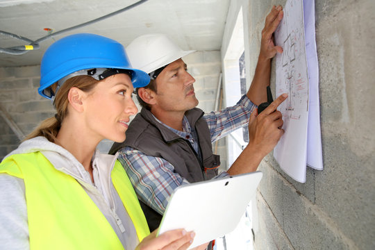 Engineers on building site checking plans
