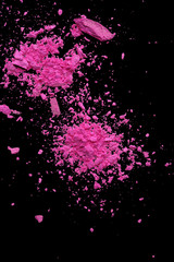 Pink makeup powder explosion suspension on black background