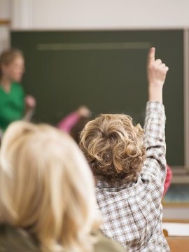 Boy (4-7) die Anhebung der Hand in der Klasse,R&uuml;ckansicht