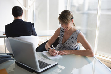 Business-Frau mit Headset sich Notizen