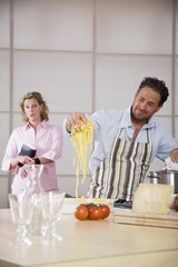 Man Kochen,Frau im Hintergrund