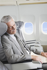 Deutschland,Bayern,München,Senior Geschäftsmann schlafen im Business-Class- Flugzeug-Kabine