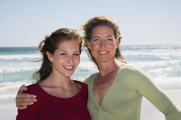 Fototapeta premium Mutter und Tochter stehen am Strand,lächelnd,Porträt