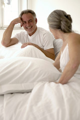 Älteres Paar sitzt auf dem Bett,Mann lächelnd,close-up
