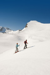 Fototapeta na wymiar  Zauchensee , Junges Paar Langlauf in den Bergen, Seitenansicht