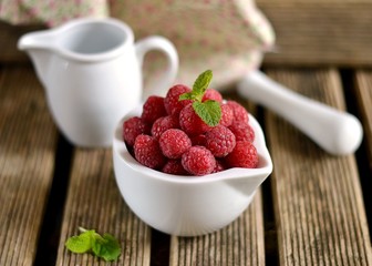 Raspberries in a bowl on wooden background
