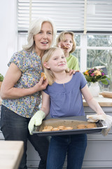 Enkelin (8-9) hält Tablett mit Keksen,lächelnd,Porträt