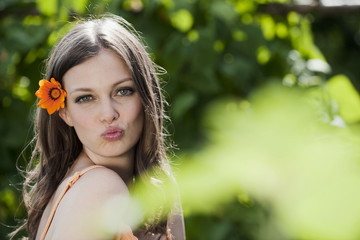 Deutschland,Bayern,Frau mit Blume im Haar,aufgeworfenen Lippen,Portrait