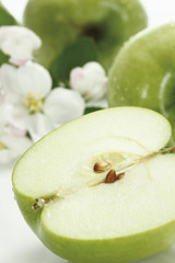 Geschnitten grünen Apfel und Apfelblüte, close-up