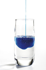 Glas mit blauen und durchsichtigen Flüssigkeiten