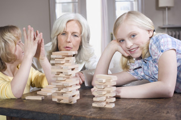 Großmutter und Enkelkinder (8-9),die zusammen spielen,Portrait